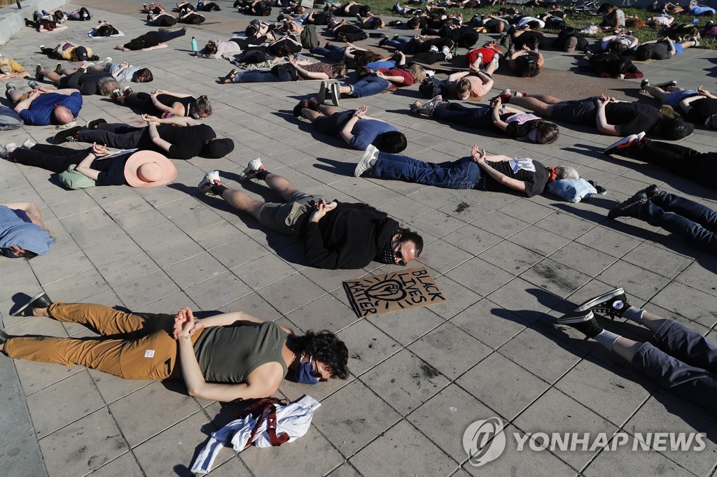 지난 10일(현지시간) 캘리포니아에서 시위대가 조지 플로이드의 체포 모습을 재현하고 있다.