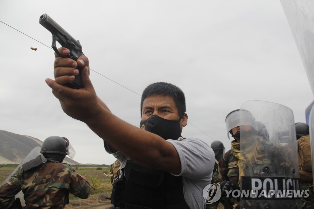 지난해 12월 30일 페루 농민 시위대를 향해 총을 겨눈 경찰의 사진. 