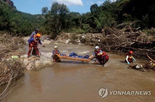 지난 4월 남아공 더반 근처에서 홍수로 숨진 여자아이의 시신을 수습하는 구조대