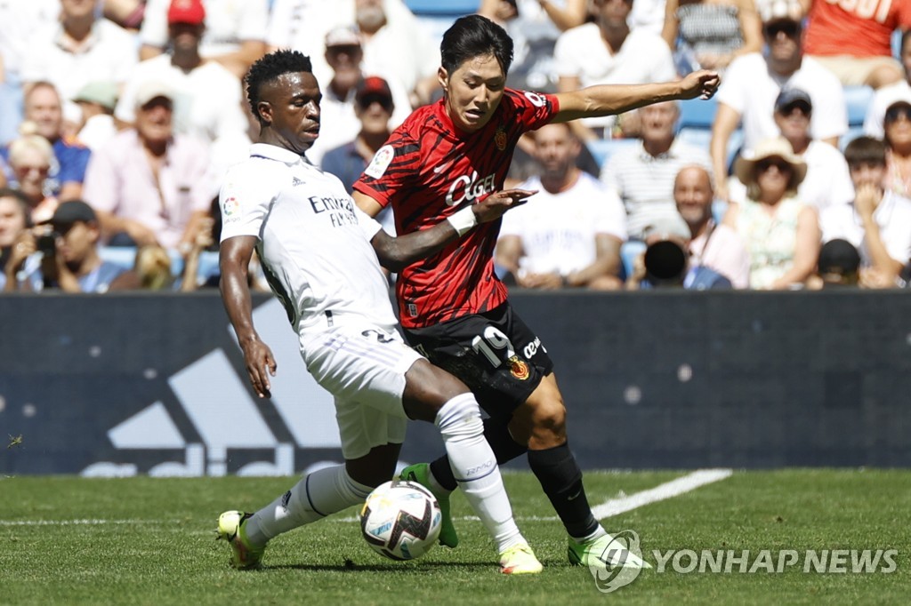 In this EPA photo, Lee Kang-in of RCD Mallorca (R) battles Vinicius Jr. of Real Madrid for the ball during the clubs' La Liga match at Santiago Bernabeu Stadium in Madrid on Sept. 11, 2022. (Yonhap)