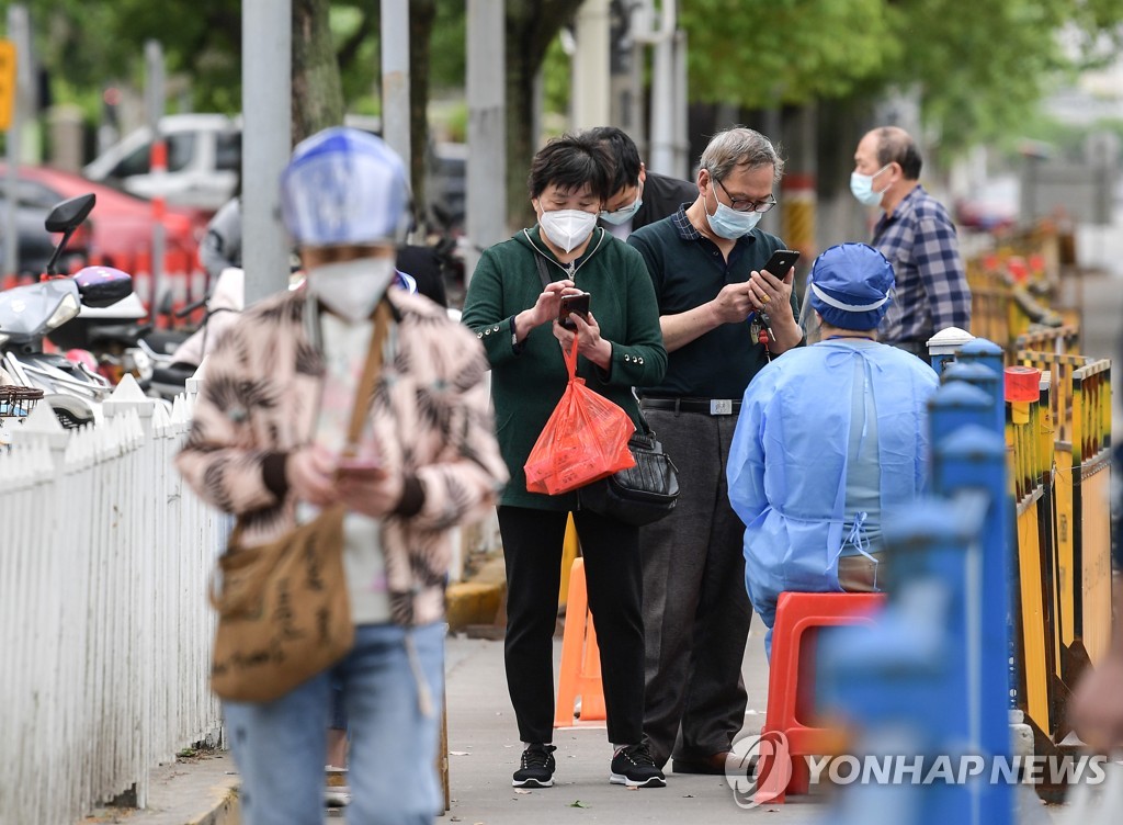 (신화=연합뉴스) 지난 10일 상하이 주민들이 시장에 들어가기 위해 코로나19 음성 증명서를 제시하는 모습. 2022.5.11.