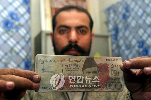 2007년 파키스탄 퀘타에서 한 경찰이 최고액권인 5천루피 위조지폐를 들어 보이고 있다.[EPA=연합뉴스 자료사진]
