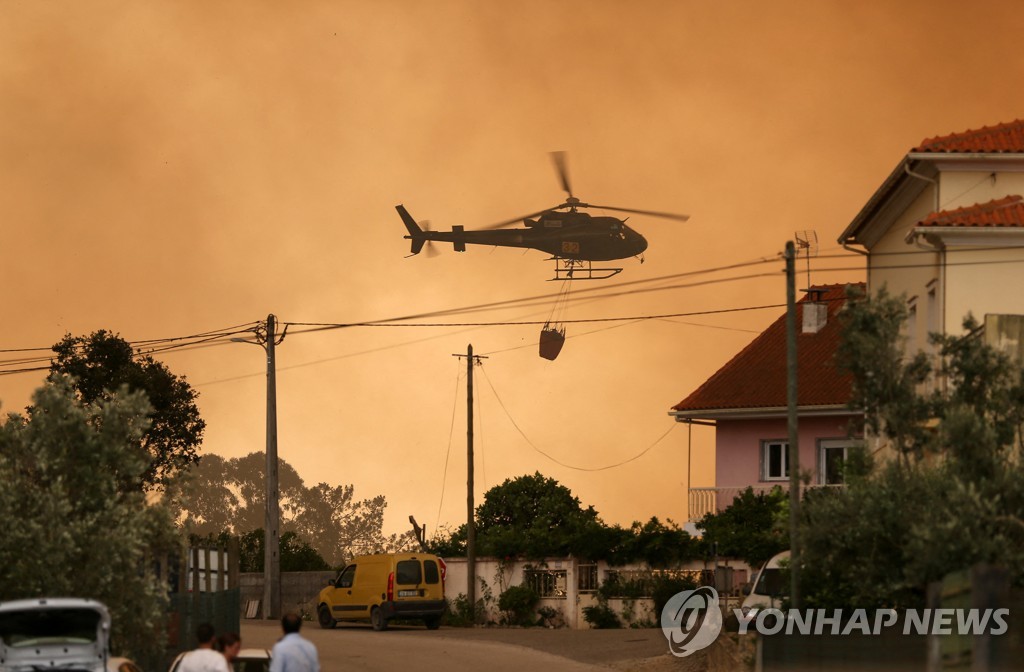 Firefighting helicopters try to extinguish forest fires in Portugal