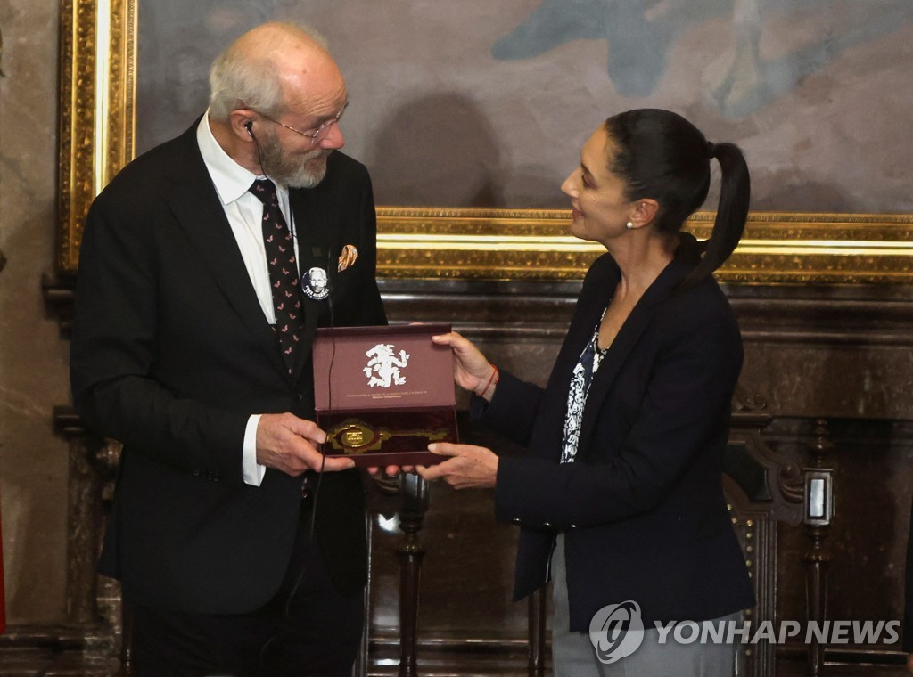 줄리언 어산지 부친에게 도시 상징 열쇠 전달하는 멕시코 시장
