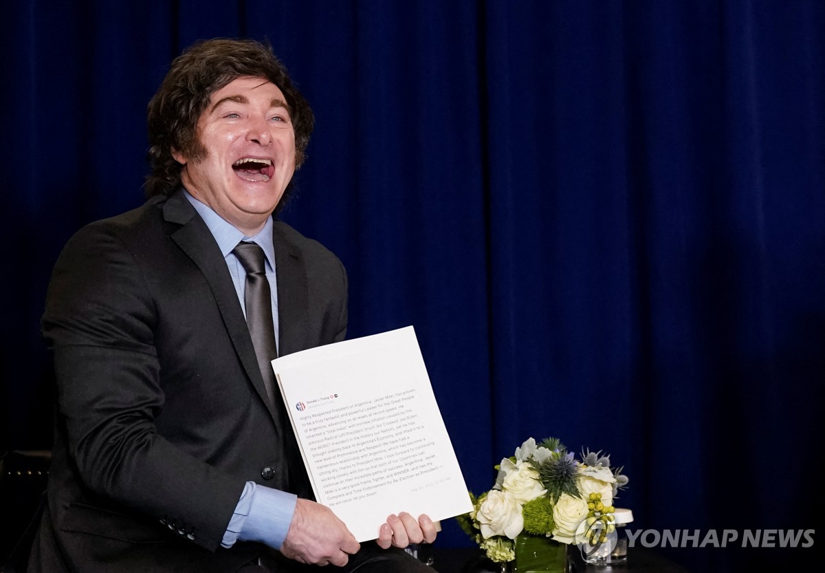 트럼프 대통령으로부터 트루스소셜 게시글 인쇄물을 받고 환하게 웃는 밀레이 대통령