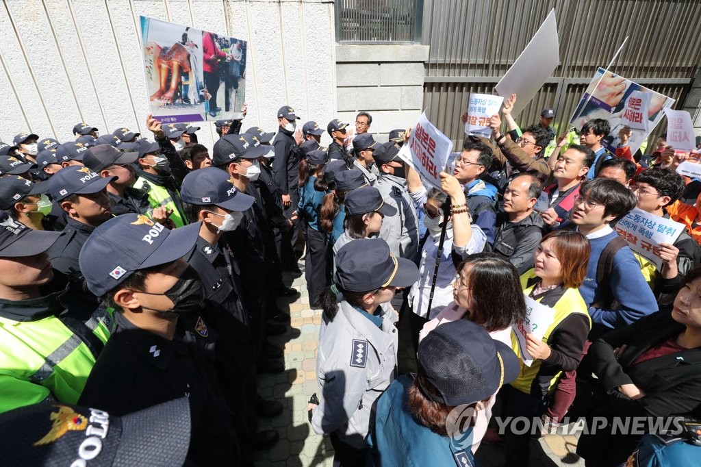 釜山の日本総領事館前で警察と対峙（たいじ）する市民団体の会員。記者会見後、徴用工像が置かれている場所へ移動しようとしたが阻まれた＝３日、釜山（聯合ニュース）
