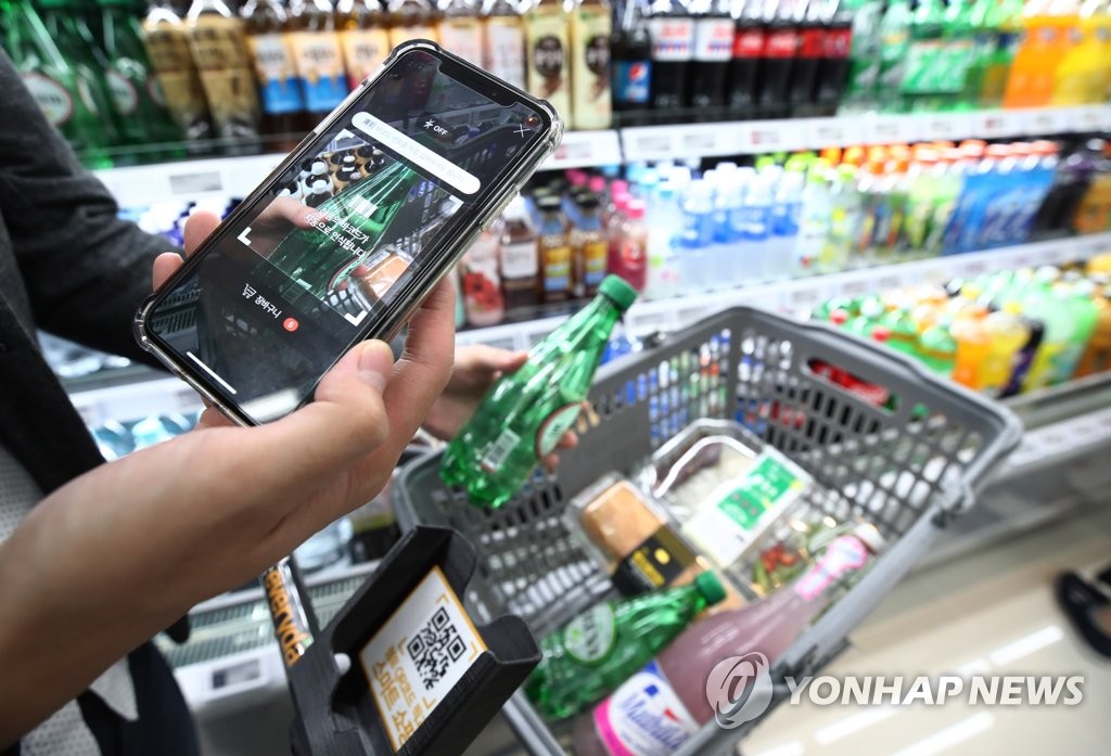 In this photo taken on Aug. 17, 2018, a customer scans the bar code of a product using retail giant Shinsegae's mobile app at its cashier-less store in Seoul. (Yonhap) 