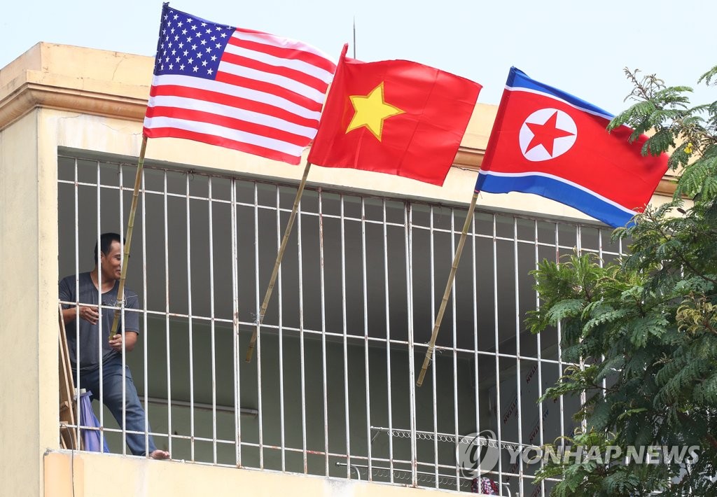 A resident hangs the national flags of Vietnam, North Korea and the United States at his house near JW Marriott Hotel in Hanoi on Feb. 21, 2019. The second U.S.-North Korea summit is slated for Feb. 27-28 in the Vietnamese capital. (Yonhap)
