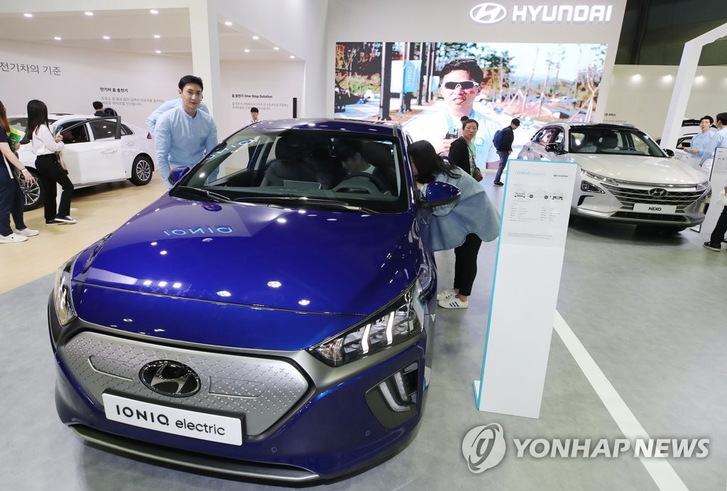 In this photo taken May 2, 2019, visitors take a look at Hyundai Motor's Ioniq electric car displayed at the EV Trend Korea exhibition in southern Seoul. (Yonhap)