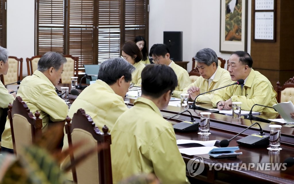 President Moon Jae-in (L) receives a briefing from Finance Minister Hong Nam-ki (R) on the economy at Cheong Wa Dae on May 28, 2019, in this photo provided by the presidential office. (Yonhap)