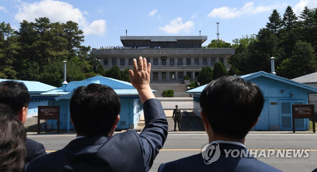 The leadership of South Korea's ruling Democratic Party, led by Chairman Lee Hae-chan, waves toward North Korean students visiting the inter-Korean truce village of Panmunjom on the southern side of the village on May 31, 2019. Lee's group was on a security tour to the village on the occasion of the first anniversary of the April 27 joint declaration made between South Korean President Moon Jae-in and North Korean leader Kim Jong-un. (pool photo) (Yonhap)