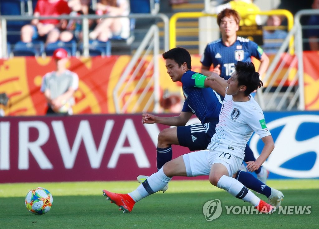 Lee Kang-in of South Korea (R) and Mitsuki Saito of Japan battle for the loose ball during their teams' round of 16 match at the FIFA U-20 World Cup at Lublin Stadium in Lublin, Poland, on June 4, 2019. (Yonhap)
