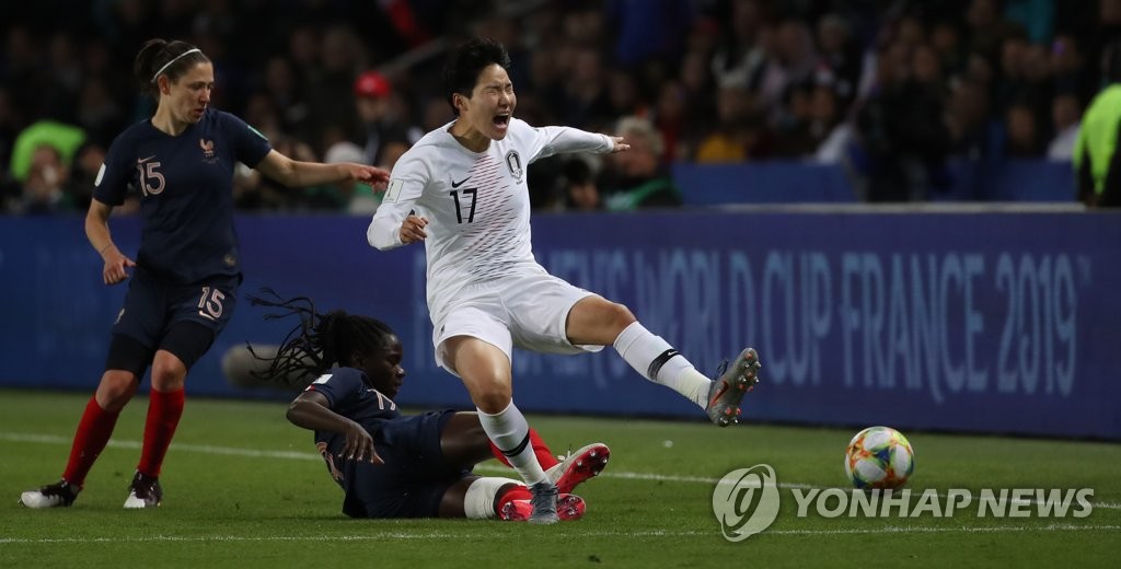 Lee Geum-min of South Korea (R) is tackled by a French player during their Group A match at the FIFA Women's World Cup at Parc des Princes in Paris on June 7, 2019. (Yonhap)
