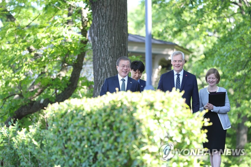 South Korean President Moon Jae-in (L) walks with Finnish Prime Minister Antti Rinne at his official residence in Helsinki on June 11, 2019. (Yonhap)