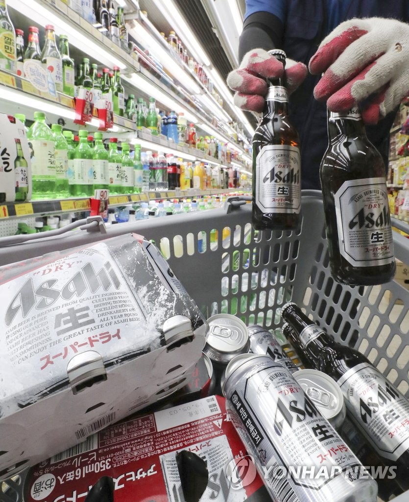 ソウル市内のスーパーで従業員が日本ビールを棚から下ろし、返品する準備をしている＝７日、ソウル（聯合ニュース）