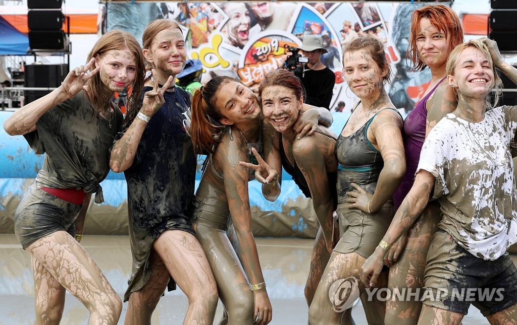 This photo taken July 21, 2019 shows a group of foreign tourists enjoying the Boryeong Mud Festival on a beach in Daecheon, a city located some 190 kilometers southwest of Seoul. (Yonhap)