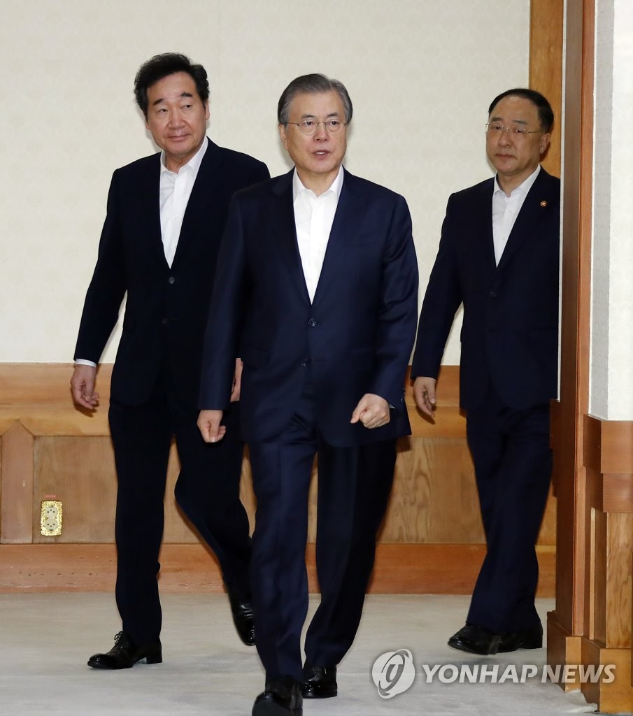 In this file photo, taken Oct. 8, 2019, President Moon Jae-in (C) enters a Cheong Wa Dae conference room along with Prime Minister Lee Nak-yon (L) and Finance Minister Hong Nam-ki. (Yonhap)