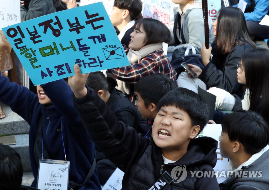 An elementary school student holds a sign that says, "The Japanese government should apologize to grandmothers," at the weekly rallies held every Wednesday in central Seoul on Oct. 30, 2019. (Yonhap)
