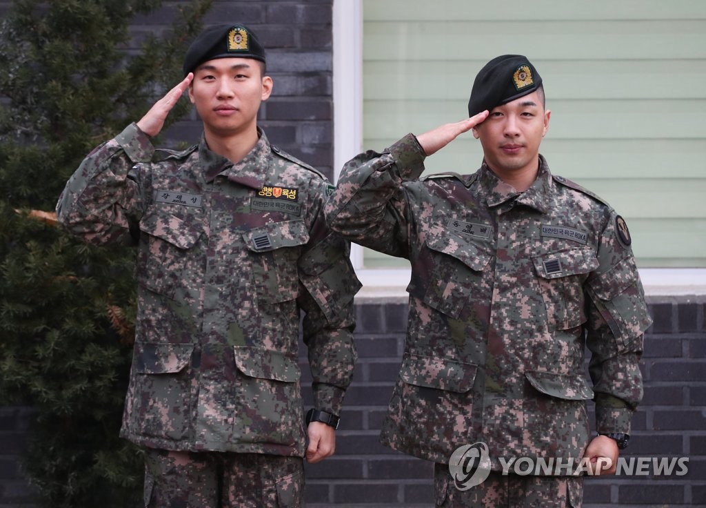 11月10日，在京畿道龙仁市地面作战司令部前，BIGBANG成员太阳（右）和大成敬军礼。当天，二人正式退伍。 韩联社
