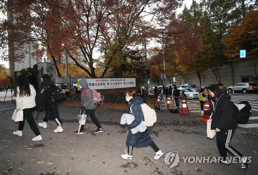 Students bundled up against the cold enter Seoul Banpo High School to take the national college entrance exam on Nov. 14, 2019. (Yonhap)