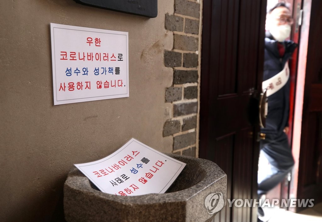 This Feb. 2, 2020, photo shows notices at Myeongdong Cathedral describing the cathedral's decision not to use holy water or shared hymn books. (Yonhap)