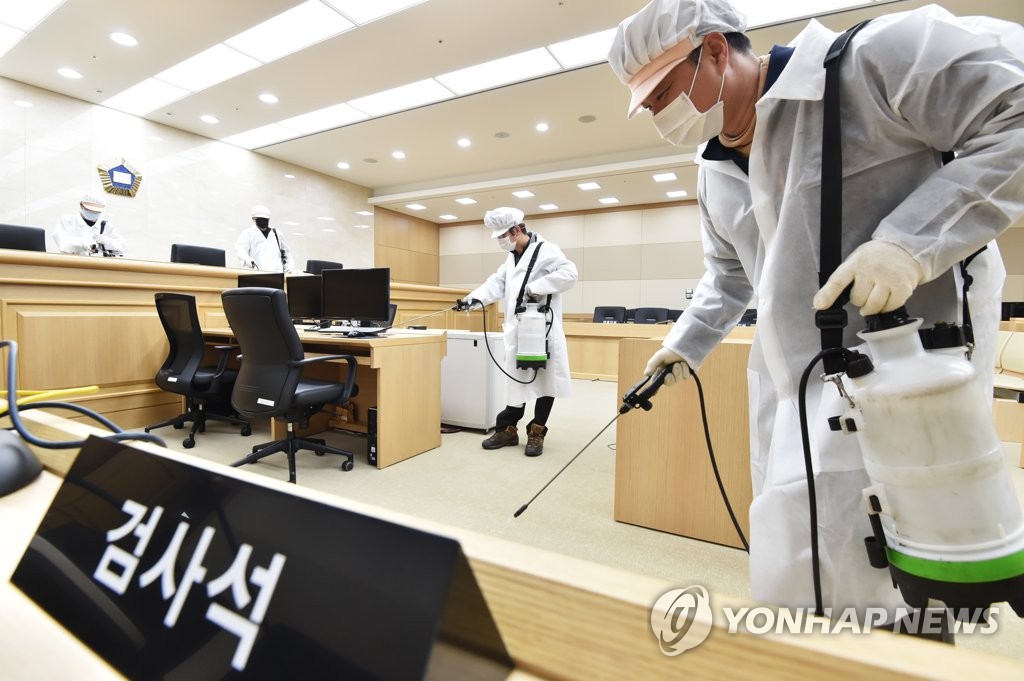 Health workers disinfect a courtroom in Suwon, south of Seoul, on March 1, 2020, as South Korea beefs up its efforts to prevent the spread of the novel coronavirus. (Yonhap)
