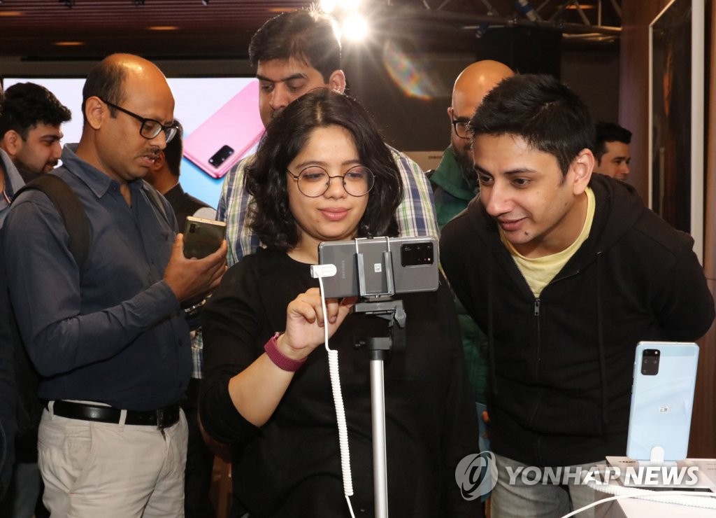 This photo, provided by Samsung Electronics Co. on March 6, 2020, shows Indian consumers inspecting the company's Galaxy S20 smartphones at an event in Gurugram, India. (PHOTO NOT FOR SALE) (Yonhap)