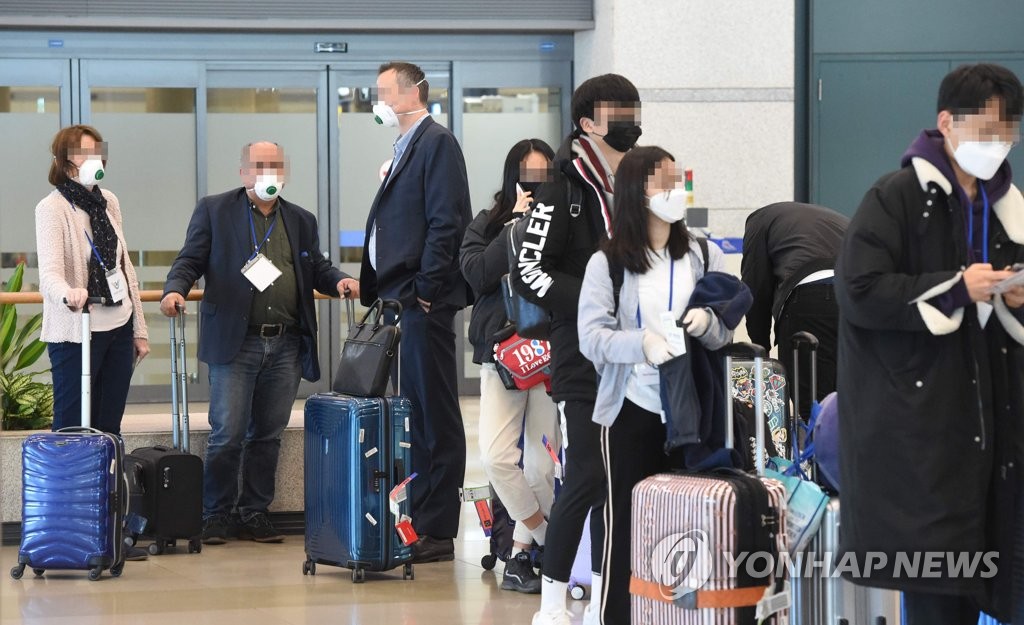 This photo taken on March 22, 2020, shows travelers from Frankfurt, Germany, waiting in line for virus tests at Incheon International Airport in Incheon. (Yonhap)