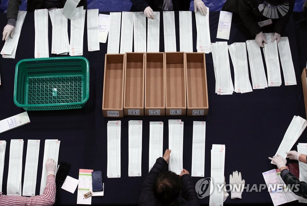 ソウル市内の開票所で行われた比例の開票作業＝１５日、ソウル（聯合ニュース）