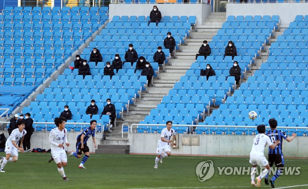 A practice match between Incheon United (in blue) and Suwon FC takes place at Incheon Football Stadium in Incheon, 40 kilometers west of Seoul, while coaches and reserves watch from the stands, on April 23, 2020. (Yonhap)