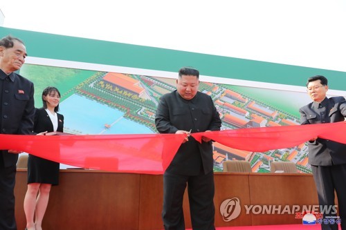 North Korean leader Kim Jong-un (C) cuts a ribbon during a ceremony to mark the completion of a phosphatic fertilizer factory in Sunchon, north of Pyongyang, on May 1, 2020, in this photo released the next day by North Korea's official Korean Central News Agency. Kim made his first public appearance after a 20-day absence that sparked rumors about his health. (For Use Only in the Republic of Korea. No Redistribution) (Yonhap)