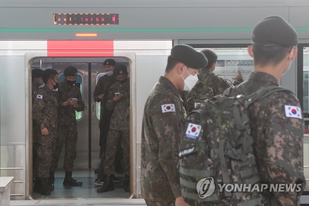 Soldiers board a train at a station in Paju, north of Seoul, on May 8, 2020, as they were allowed to go on vacation after more than two months of restrictions amid fears about the spread of the new coronavirus. The military began to lift the restrictions on vacationing the same day in line with the government's decision to end a weekslong, strict social distancing campaign amid signs of a slowdown in virus infections. (Yonhap)