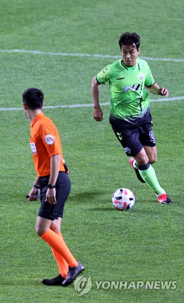 Lee Dong-gook of Jeonbuk Hyundai Motors (R) controls the ball during the 2020 K League 1 season opener against Suwon Samsung Bluewings at Jeonju World Cup Stadium in Jeonju, 240 kilometers south of Seoul, on May 8, 2020. (Yonhap)