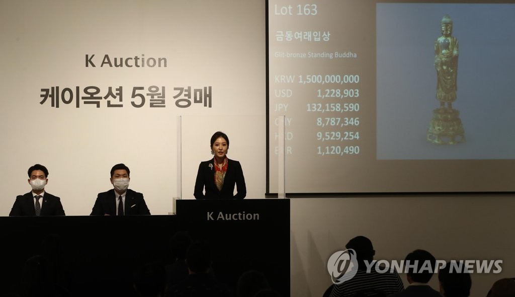 An auctioneer presents Gilt-bronze Standing Buddha, which dates back to the middle of the 7th century during the period of Unified Silla (668-918), at K Auction in southern Seoul on May 27, 2020. (Yonhap)