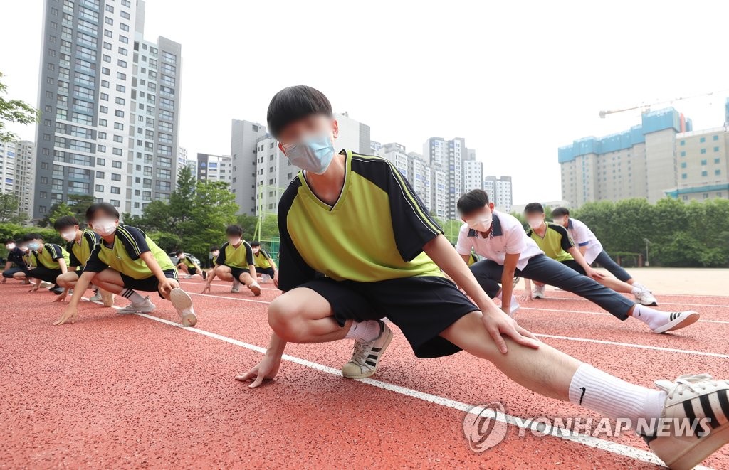 Students stretch during a physical education class at Gwacheon High School in Gwacheon, south of Seoul, on June 3, 2020, when South Korea implemented the third phase of school reopening for high school first graders, middle school second graders and elementary school third and fourth graders. (Yonhap)