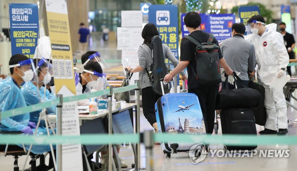 Health officials instruct international arrivals on their transportation options at Incheon International Airport, South Korea's main gateway west of Seoul, on July 12, 2020. The country began on July 13 to require arrivals from high-risk nations to hand in a certificate showing they tested negative for COVID-19. (Yonhap)