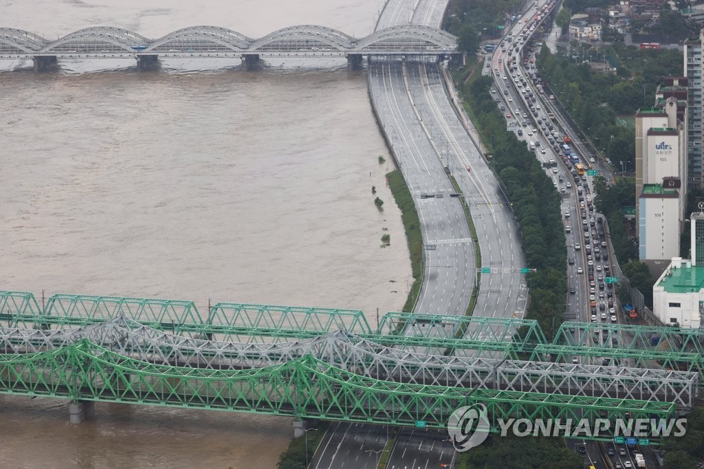 Olympic Expressway (L), a highway that connects southern Seoul with nearby Gyeonggi Province, is empty on Aug. 3, 2020, as entry was banned amid heavy rain. (Yonhap)