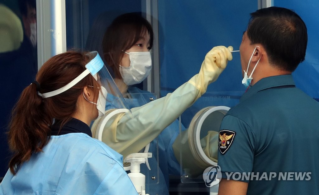 A police officer who was dispatched to the Liberation Day rally site is tested for the new coronavirus at a screening center set up at the Seoul Metropolitan Police Agency in central Seoul on Aug. 19, 2020. (Yonhap)