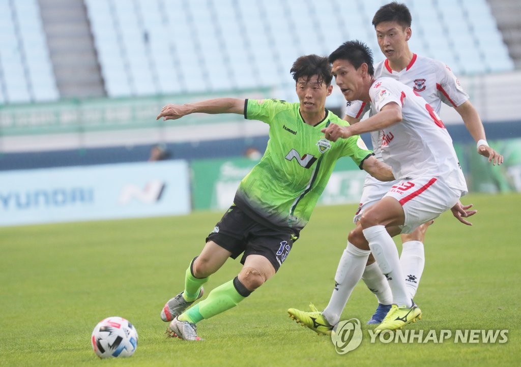 In this file photo from Aug. 23, 2020, Kim Bo-kyung of Jeonbuk Hyundai Motors (L) tries to dribble past a Sangju Sangmu player during their K League 1 match at Jeonju World Cup Stadium in Jeonju, 240 kilometers south of Seoul. (Yonhap)