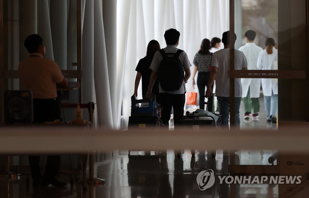 A group of people moves chairs and pickets used in the doctors' strike at a general hospital in Seoul after the Korean Medical Association, the ruling Democratic Party and the health ministry agreed to end the strike on Sept. 4, 2020. (Yonhap)