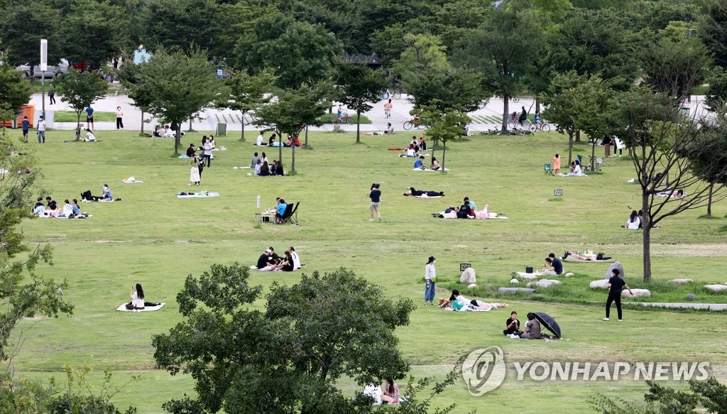 Seoul citizens spend the weekend at a riverside park in Yeouido, western Seoul, on Sept. 6, 2020, as the government extended stricter virus curbs in greater Seoul by another week. (Yonhap)