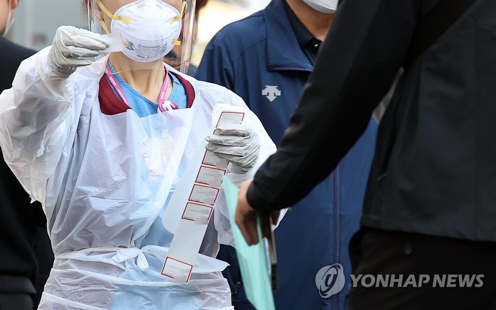 A medical worker carries out new coronavirus tests at a makeshift clinic in central Seoul on Oct. 6, 2020. (Yonhap)