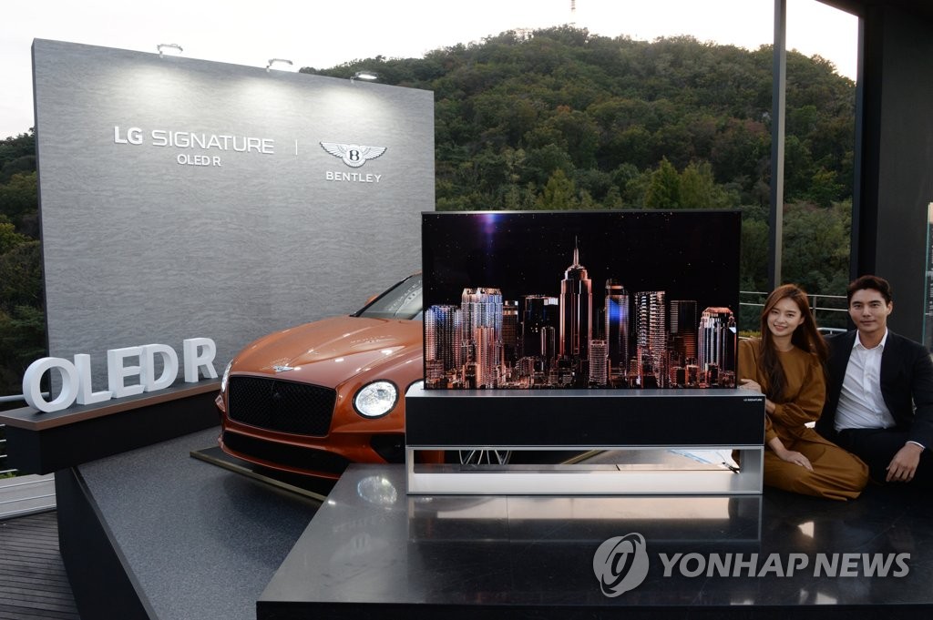 This photo provided by LG Electronics Inc. on Oct. 14, 2020, shows models promoting the company's rollable TV, the Signature R, with a Bentley Continental GT at an event for VVIP (very very important person) consumers at a Seoul hotel. (PHOTO NOT FOR SALE) (Yonhap)
