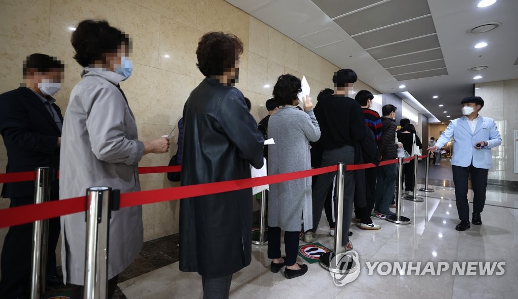 Citizens wait in line to receive a free flu shot at a medical center in Seoul on Oct. 19, 2020. (Yonhap)