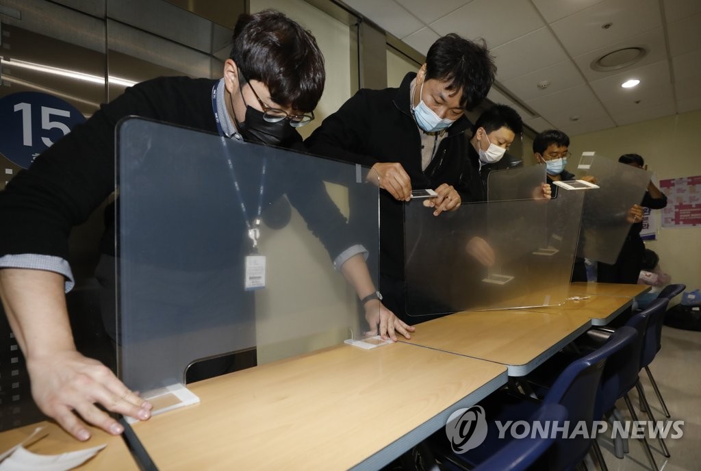 Des officiels installent des parois en plastique au Centre médical de Séoul (SMC) pour des candidats atteints du Covid-19, le mercredi 2 décembre 2020. 