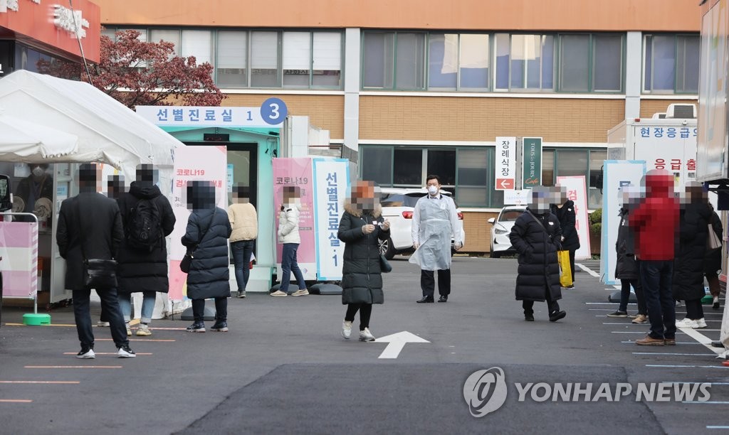 People wait in line to get tested at a coronavirus test center in downtown Seoul on Dec. 6, 2020. (Yonhap)