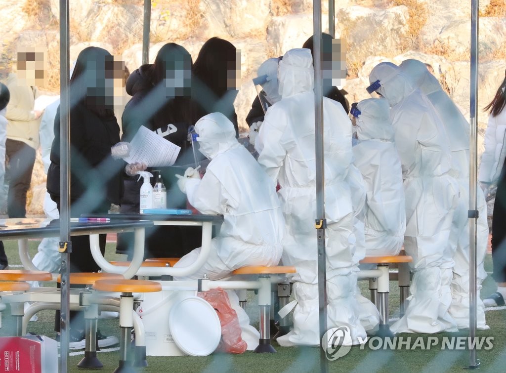 Health officials carry out COVID-19 tests on students and staffs of a middle school in the southeastern port city of Ulsan on Dec. 8, 2020. (Yonhap) 