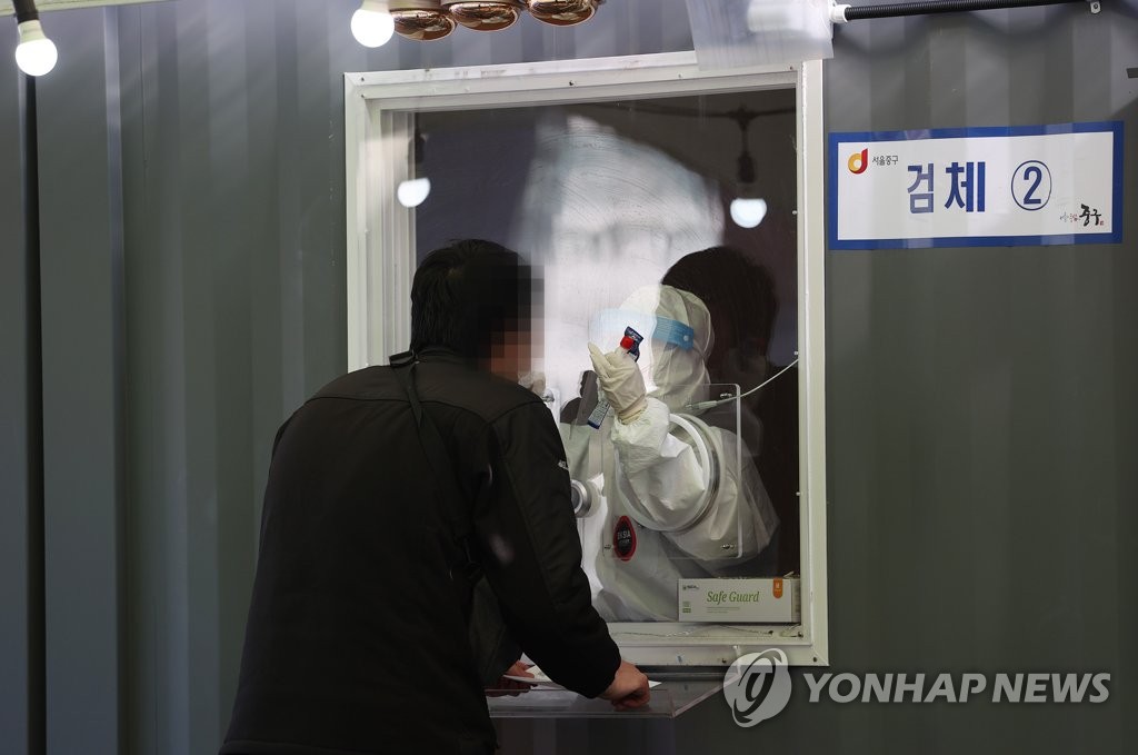 A health worker conducts a coronavirus test on a citizen at a temporary testing site in front of Seoul Station in central Seoul on Jan. 24, 2021. (Yonhap)