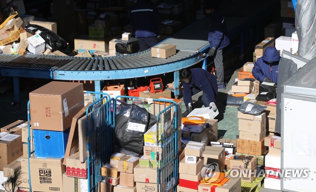 Workers sort parcels at a distribution center in Hwaseong, 42 km south of Seoul, on Jan. 29, 2021. (Yonhap)