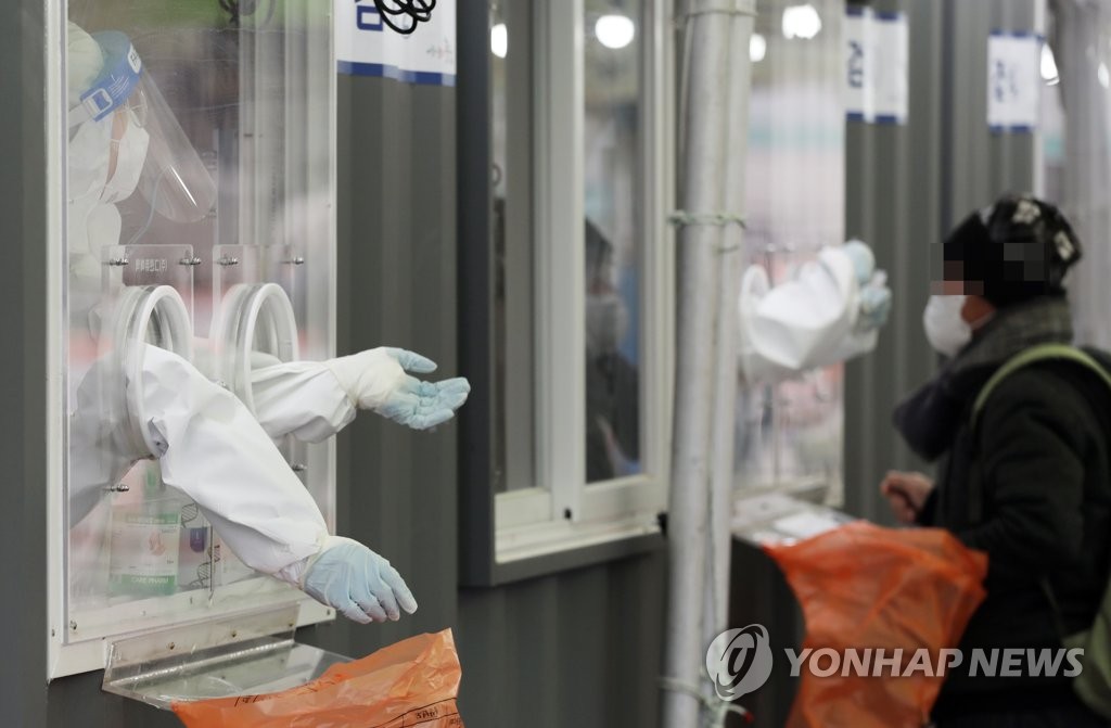 A medical worker prepares to administer a coronavirus test at a makeshift testing facility in Seoul on Feb. 7, 2021. (Yonhap)